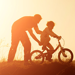 Father teaching a child to ride a bike